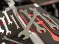 Variedad de tipos de llaves herramientas organizadas en un estuche negro con detalles rojos.