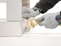 Manos enguantadas atando nudos con diferentes tipos de cuerdas a un soporte metálico.