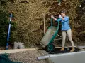 Mujer vertiendo hormigón de carretilla para como hacer una base de hormigon. Se ven herramientas y materiales de construcción.