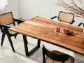 Mesa de comedor con veta madera natural y sillas de ratán.