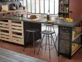 Cocina moderna con isla central y taburetes de altura taburete barra 90. Frutas, pan y vajilla sobre la encimera.