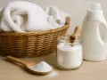 Cesta con ropa blanca, un frasco de bicarbonato y un bote de detergente. ¡Cuidado! el bicarbonato estropea la ropa de color.