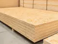 Una pila de tableros de OSB, un material de construcción versátil.