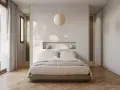 Acogedora habitación pequeña con cama baja, nicho empotrado con lámparas y gran ventanal.
