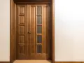 Puertas dobles de madera con paneles y vidrio, perfectas para inspirarte sobre como elegir el color de las puertas de interior.