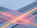 Manos sujetan metacrilato transparente sobre una guía con luces naranjas, preparándolo para moldear.