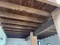 Tejado de madera a un agua con vigas rústicas y entablado oscuro. Ideal para un estilo campestre.