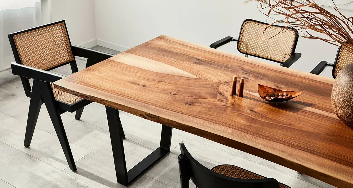 Mesa de comedor con veta madera natural y sillas de ratán.