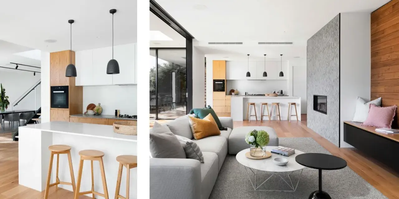 Cocina tipo americana moderna con isla, taburetes de madera y sala de estar contigua con chimenea de piedra.