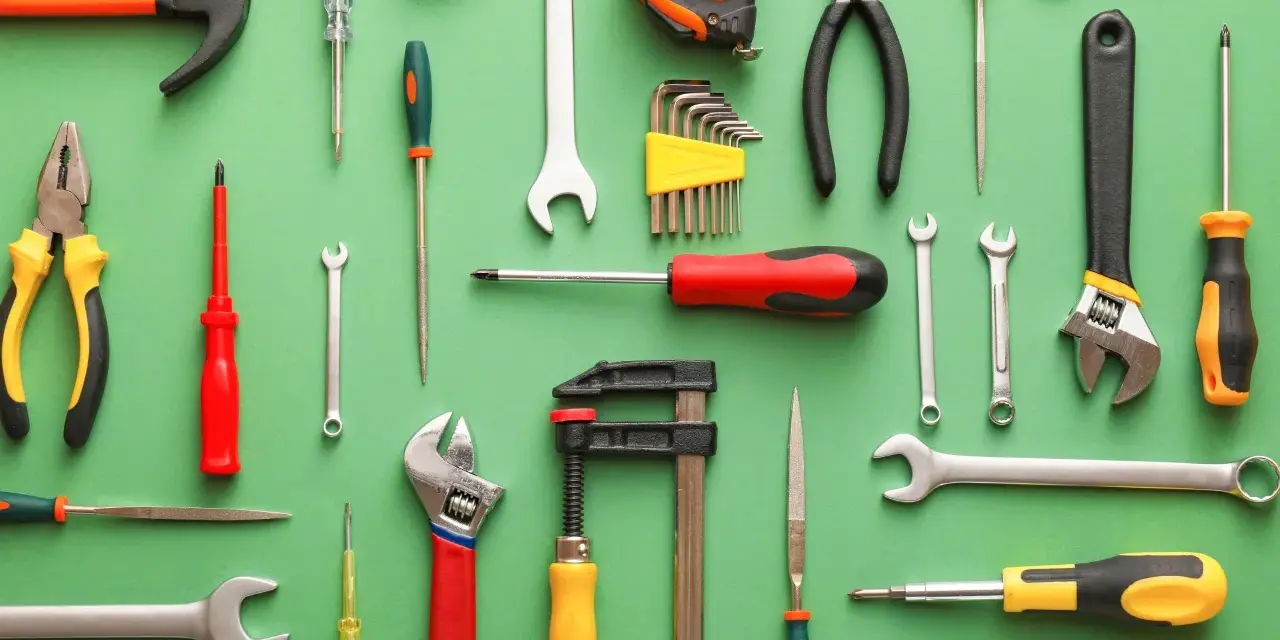 Un surtido de nombres de herramientas de construcción en España: martillo, llaves inglesas, destornilladores, alicates, cinta métrica, juego de llaves Allen y más.
