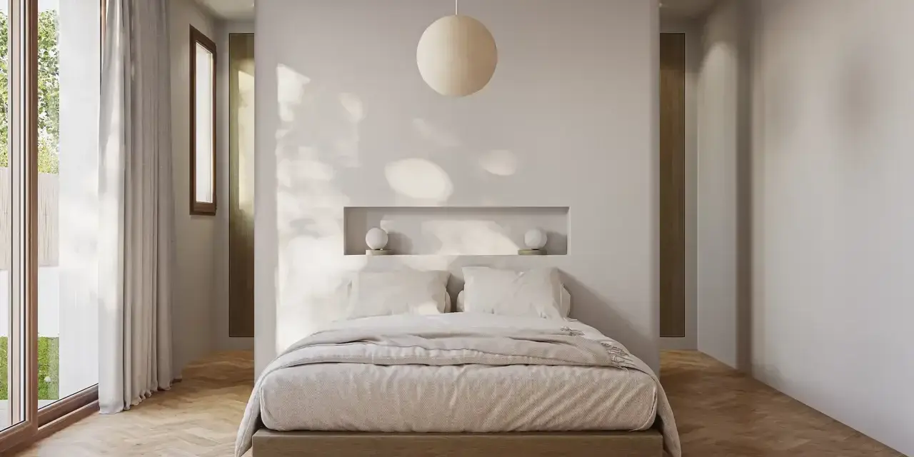 Acogedora habitación pequeña con cama baja, nicho empotrado con lámparas y gran ventanal.