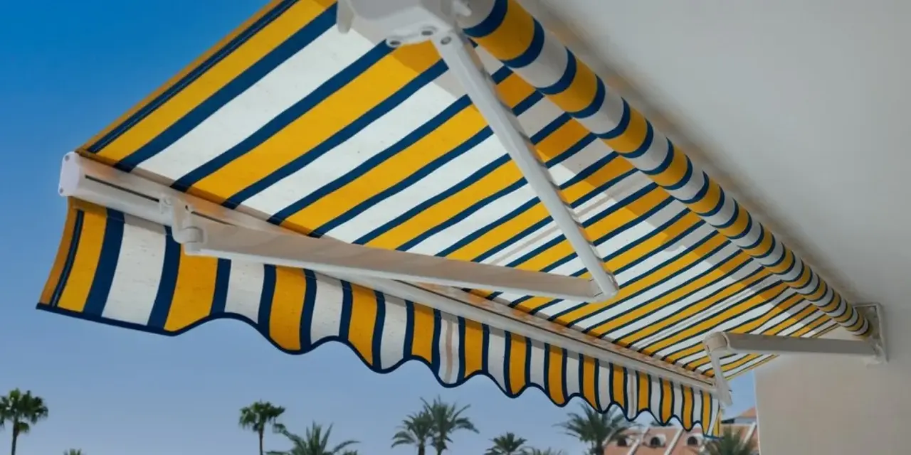 Toldo a rayas amarillas, blancas y azules, un techo corredizo casero perfecto para disfrutar del sol.