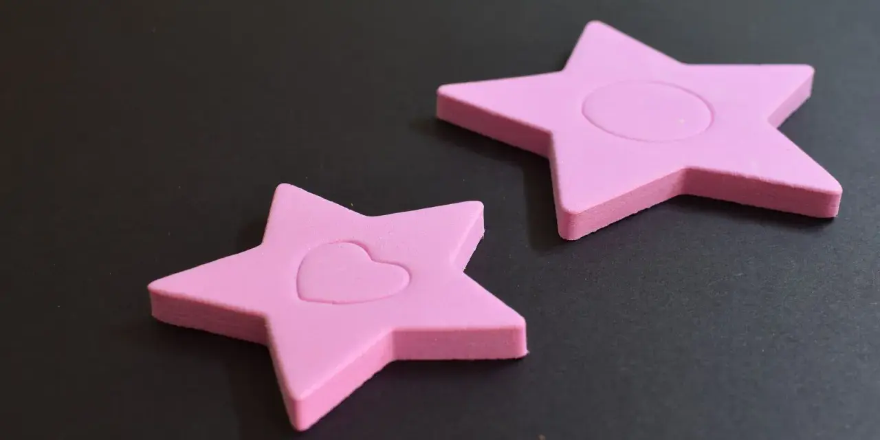Dos estrellas rosas de goma eva, una con un corazón, demuestran que la goma eva se puede mojar sin dañarse.