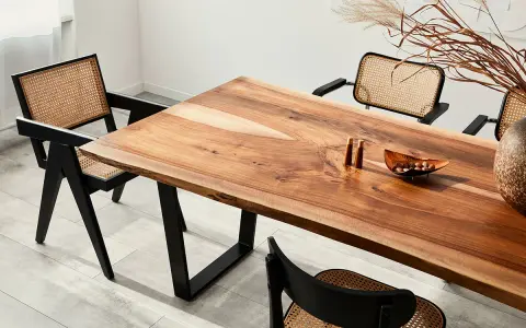 Mesa de comedor con veta madera natural y sillas de ratán.