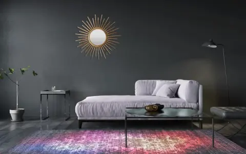 Sofá lila y alfombra vibrante sobre suelos oscuros. Un espejo sol dorado adorna la pared gris.