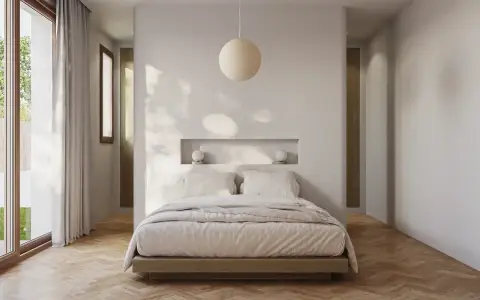 Acogedora habitación pequeña con cama baja, nicho empotrado con lámparas y gran ventanal.