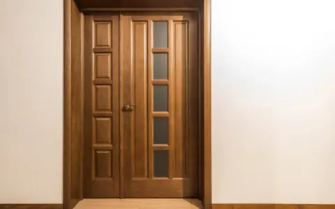 Puertas dobles de madera con paneles y vidrio, perfectas para inspirarte sobre como elegir el color de las puertas de interior.