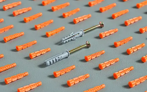 Patrón de tacos de plástico naranja y dos tacos grises con tornillos. ¡Hay muchos tipos de taco para elegir!