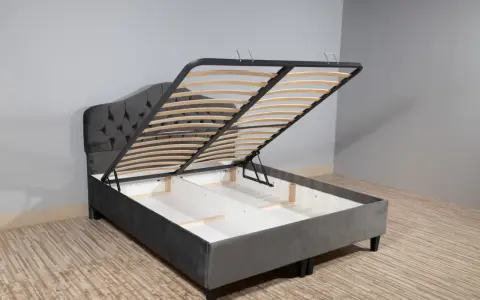 Cama canapé gris con somier abatible, ideal para almacenar.