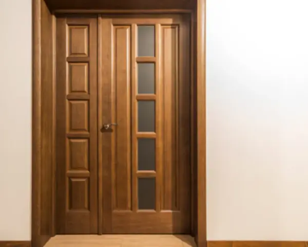 Puertas dobles de madera con paneles y vidrio, perfectas para inspirarte sobre como elegir el color de las puertas de interior.