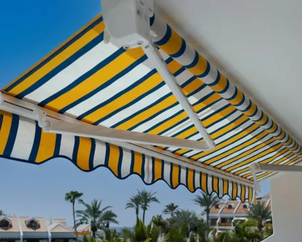 Toldo a rayas amarillas, blancas y azules, un techo corredizo casero perfecto para disfrutar del sol.