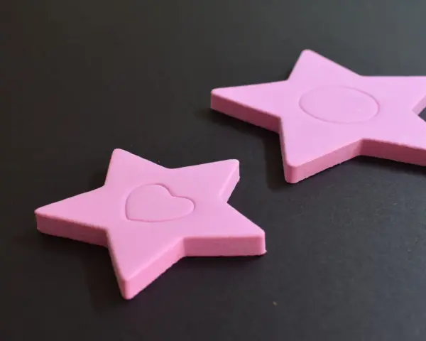 Dos estrellas rosas de goma eva, una con un corazón, demuestran que la goma eva se puede mojar sin dañarse.