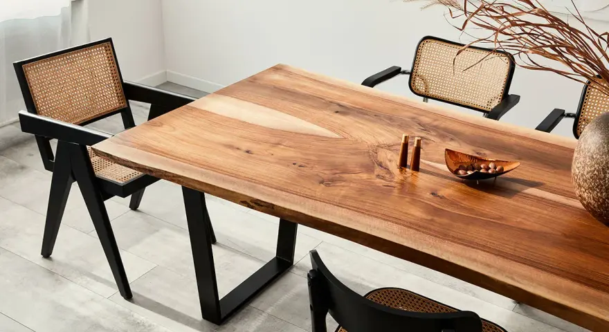 Mesa de comedor con veta madera natural y sillas de ratán.