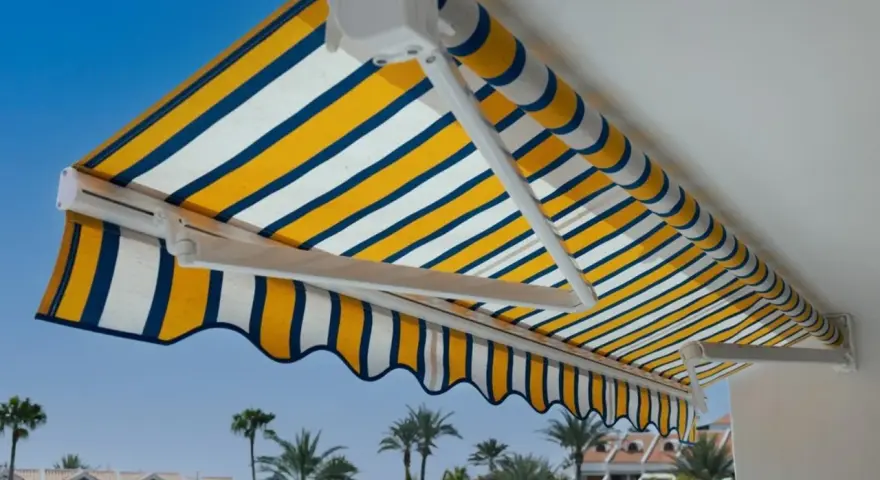 Toldo a rayas amarillas, blancas y azules, un techo corredizo casero perfecto para disfrutar del sol.