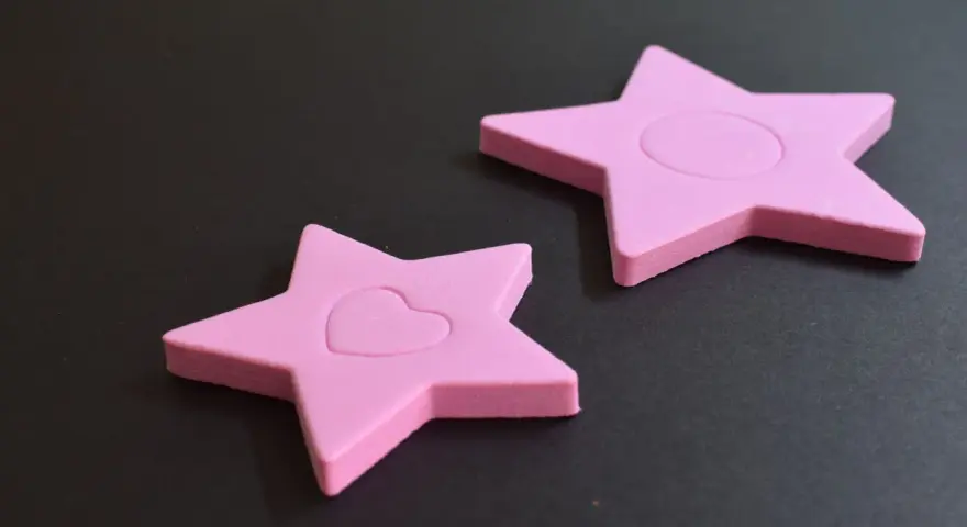 Dos estrellas rosas de goma eva, una con un corazón, demuestran que la goma eva se puede mojar sin dañarse.