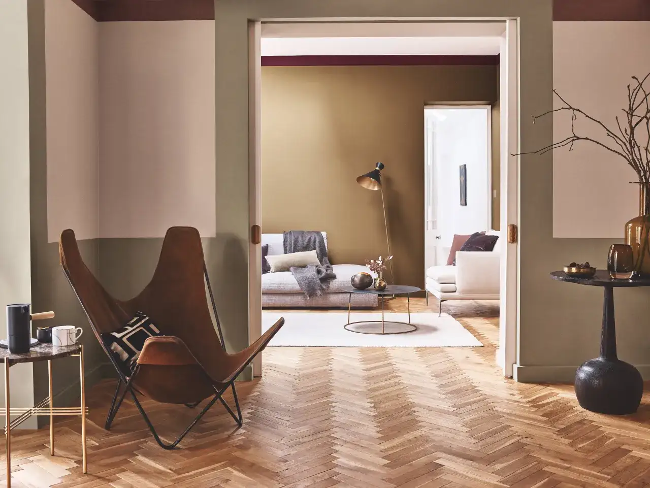 Un sal&oacute;n moderno con silla mariposa y suelo de espiga. Ideas para como elegir el color de las puertas de interior.