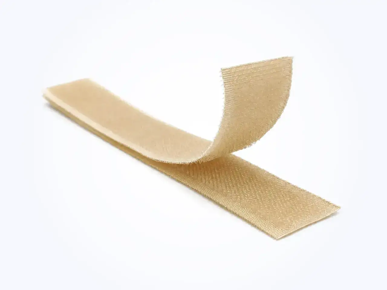 Dos tiras de velcro beige separadas, mostrando su textura de gancho y bucle. ¡Así es que funciona el velcro!