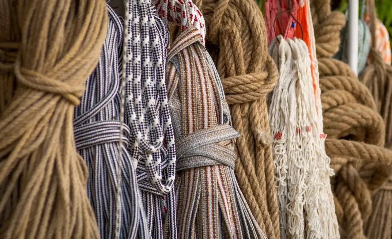 Variedad de tipos de cuerdas, desde gruesas y rústicas hasta finas y decorativas, exhibidas en un mercado.