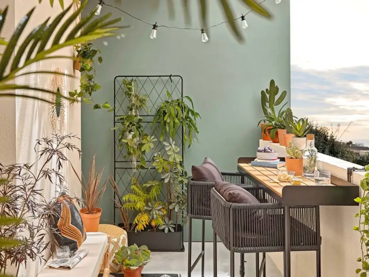 Terrazas pequeñas con encanto: un rincón verde con cactus, plantas colgantes y un espacio para disfrutar.